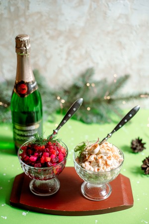 Traditional New Year and Christmas salad on holiday, on a plate, winter, New Year's still-life with champagne, old green wooden backgroundの写真素材