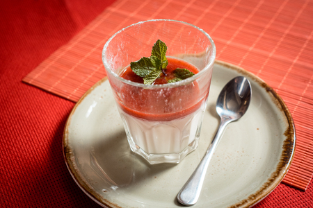 dessert with fresh strawberry, cream cheese and strawberry jam on glass. on red backgroundの写真素材