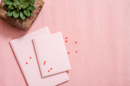 Open notebook and red hearts on pink