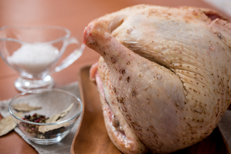 Raw goose, ready to cook, spices apples, vegetables, greens on a woodenの写真素材