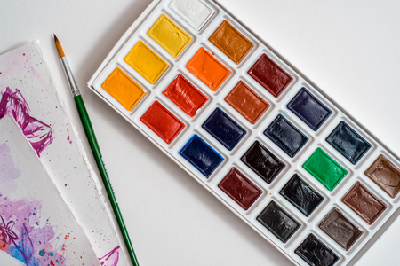 Watercolor paints, white sheet of paper and brushes View from above.の写真素材