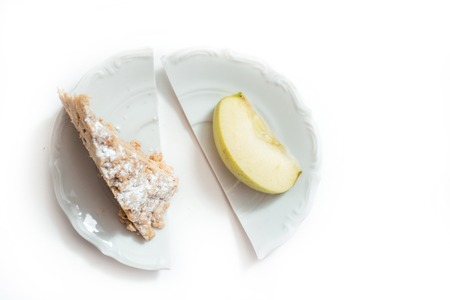 apple vs cupcake - snack decision between healthy food or junk food Broken plate. Concept of choice, diet and weight loss.の写真素材