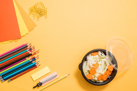 Healthy school lunch for child or teenager. Craft paper package, pile of exercise books, food in lunch box on white wood table. copy spaceの写真素材