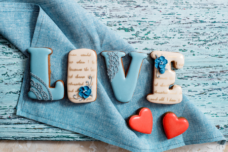 Homemade gingerbread with letters love for Valentine's Day on a background, Red icing, valentine hearts, top view. copy space.の写真素材