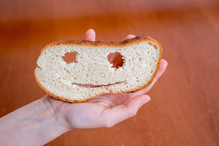 Jokes on the day of the fool. Baton in the form of a smile. Smile and eyes in bread. Pimples and fun. The concept of the April holiday jokesの写真素材