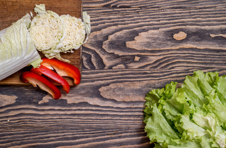 Fresh green Lettuce, cabbage, sweet red pepper on a wooden background. Vegetarian vegetables for...