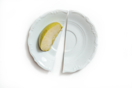 fresh green apple on a plate isolated on white background. The concept of weight loss and diet. Broken beautiful plateの写真素材