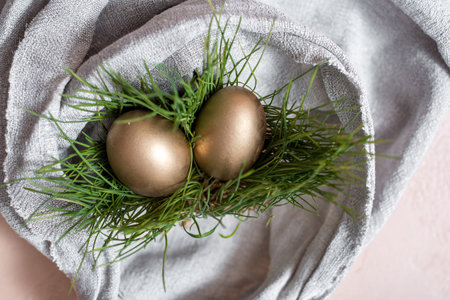 golden easter eggs. In the nest. gray linen tablecloth. easter concept, or the concept of wealth and...