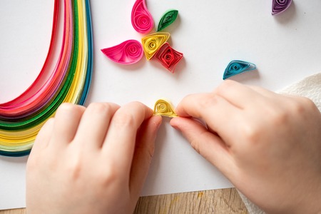 Quilling technique. Making decorations or greeting card. Paper strips, flower, scissors. Handmade crafts on holiday: Birthday, Mother's or Father's Day, March 8, Wedding. Children's DIY conceptの写真素材