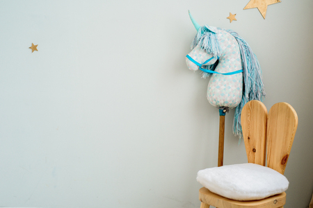 Child dream concept. Cosy bedroom decorated with toys and stars. Unicorn pillow, toy horse and two children's chairs in the form of a hare. copy spaceの写真素材