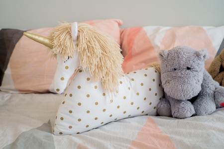Children's concept, a pillow unicorn on blood. children's room. early morning with your favorite toy unicornの写真素材