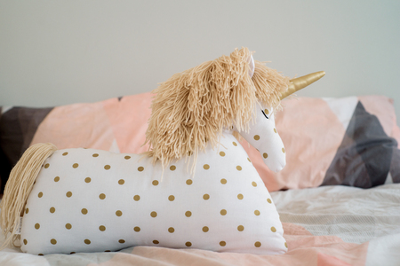 Children's concept, a pillow unicorn on blood. children's room. early morning with your favorite toy unicornの写真素材