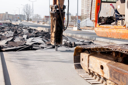 Road repairing works with jackhammer. machine drills asphalt. Large fragments of land and pits...
