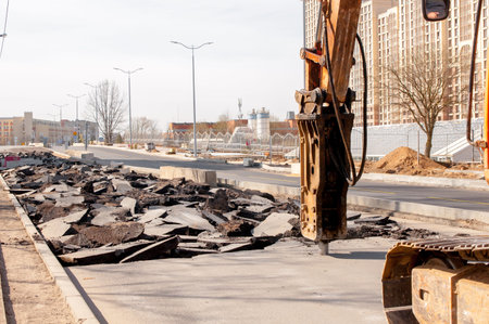 Road repairing works with jackhammer. machine drills asphalt. Large fragments of land and pits...