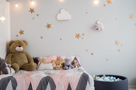 Teddy bear between paper bags and wooden chairs in child's roomの写真素材