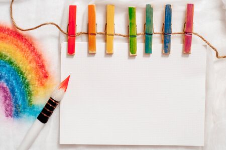 Painting of rainbow on notebook or sketch book with paintbrush on wooden planksの写真素材