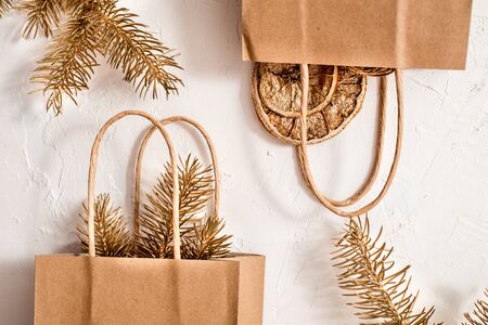 Vintage gift boxes in craft paper and a letter on white background. Presents decorated with natural parts. Christmas or other holiday concept, top view, flat layの写真素材