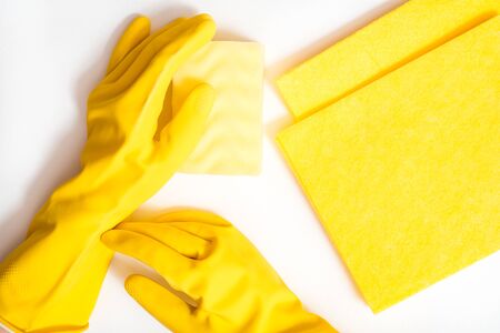 Cleaning the house and sanitation topic: Hand holding a yellow sponge wet with foam isolated on a white background in studio.の写真素材
