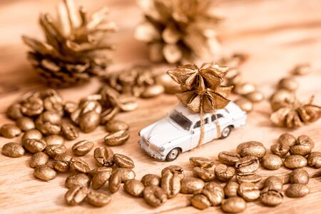 Little toy car with cookie and candy,Golden paint on coffee beans, cozy christmas on wooden backgroundの写真素材