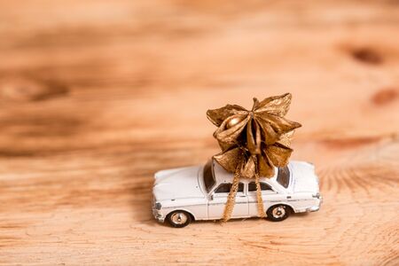 merry christmas and happy new year. modern presents, car toy with tree, anise cones and wooden background. seasonal greetings. happy holidays, xmas cardの写真素材