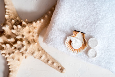 Tissue face masks in round pills. Scattered from the craft package. seashells. White bath towel on a...