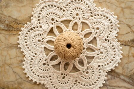 threads, crocheted round napkin.Balls of thread in a wicker box. White napkin like a flower. on a marble light background. cozy home and handmade concept.の写真素材
