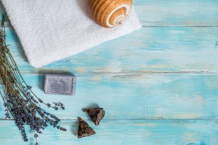 Sea spa, white towel, blue wooden old background. lavender and dry lotus flowers. sea shell. Purple bath soap. Vacation concept. copy space.の写真素材