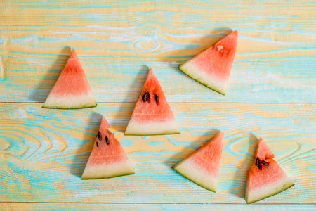 Slices of watermelon on old blue and yellow wooden background. Chopped watermelon. summer, harvest...