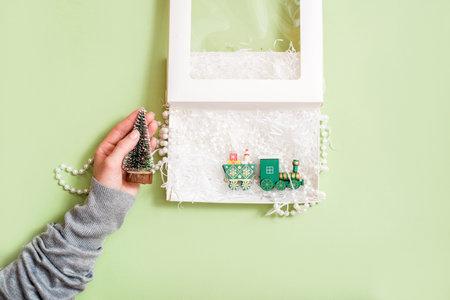 Top view of male hands opening a gift box, presents on green paper