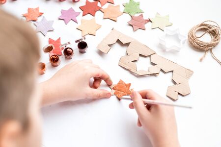 A child carves a star from cardboard.の写真素材