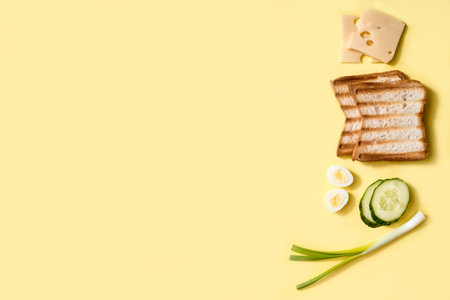 Ingredients for making sandwich. Fresh onions, champignon mushrooms, white bread, cheese and eggs. Vegetarian burger. on a yellow background, top view, copy spaceの写真素材