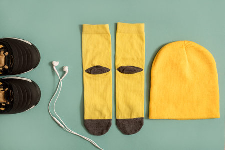 black yellow Sneakers with headphones on blue background. Music concept. Flat lay, minimal.