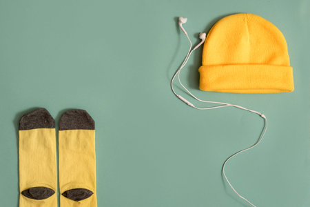 black yellow Sneakers with headphones on blue background. Music concept. Flat lay, minimal.