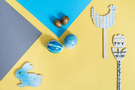 Golden easter eggs on a yellow background. blue napkin. Easter concept. copy space. Flat lay, top...