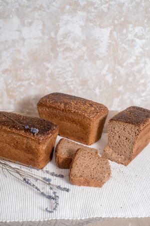 freshly baked sliced bread on rustic on wooden blue background. Women's hands take the bread in a...