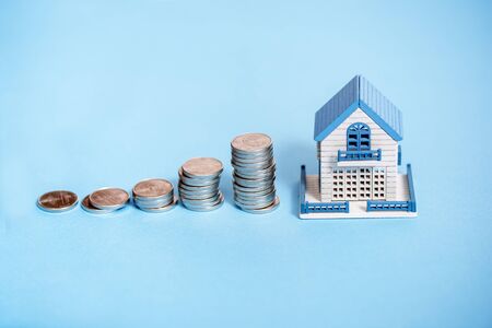Toy house, penny money, white plane. Business and success concept on blueの写真素材