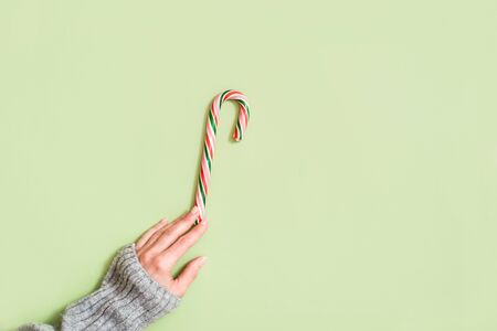 Girls hand holds a candy on greenの写真素材