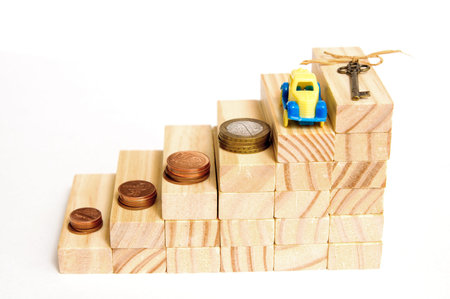 Wooden blocks step up. Money, a house key and a car.の写真素材