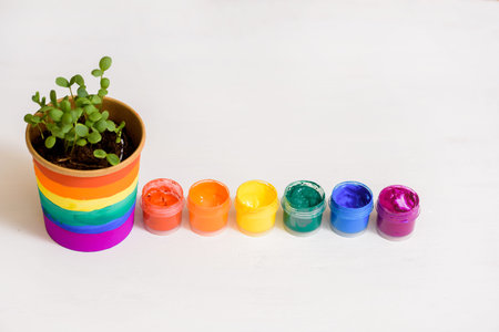 wooden art palette with paint and brushes on white. young sprouts.LGBT concept. lesbian gay ,...