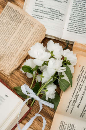 Top view of blank shabby old book with dried wild flowers on wooden table.の写真素材
