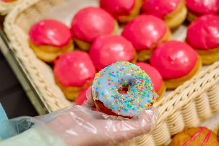 assorted sweet donuts, glazed , sprinkles in wicker basket in bakery shopの写真素材