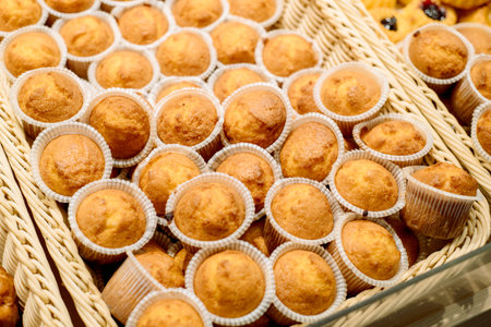 Assorted bakery. Cupcakes in the basket close-up. background
