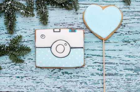 Christmas gingerbread camera on a blue wooden background.