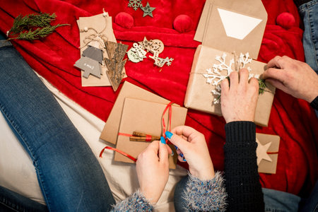 couple packing Christmas present at home. Lifestyle woman and man happy celebrate christmas and New...