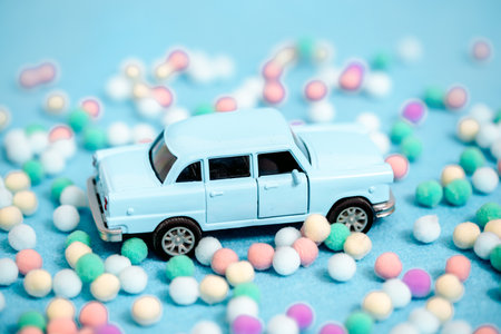 Miniature car carrying a Christmas tree on blue backgroundの写真素材