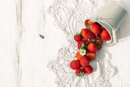 strawberries on a white wooden old background, knitted napkin, copy space.の写真素材