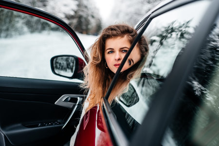 Car travel. A girl in a red car, winter travel