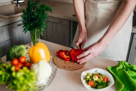 male hands chopping salad and onion, cooking healthy food in the kitchen.