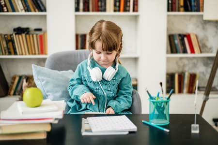 Happy child, healthy food, baby girl eating fruit at schoolの写真素材