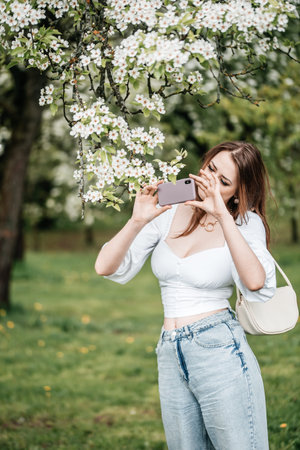 A girl with a phone in her hand takes pictures of selfies, photos for Internetの写真素材